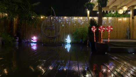 imágenes al aire libre de un jardín minimalista por la noche con iluminación cálida, luces de hadas y decoraciones navideñas