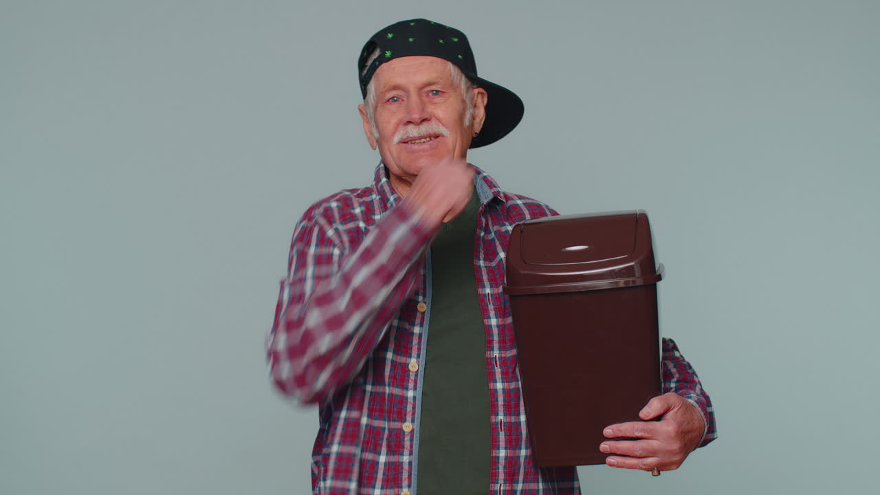 un anciano sonriente se va, tirando gafas a la basura después de la terapia de tratamiento con láser de la visión