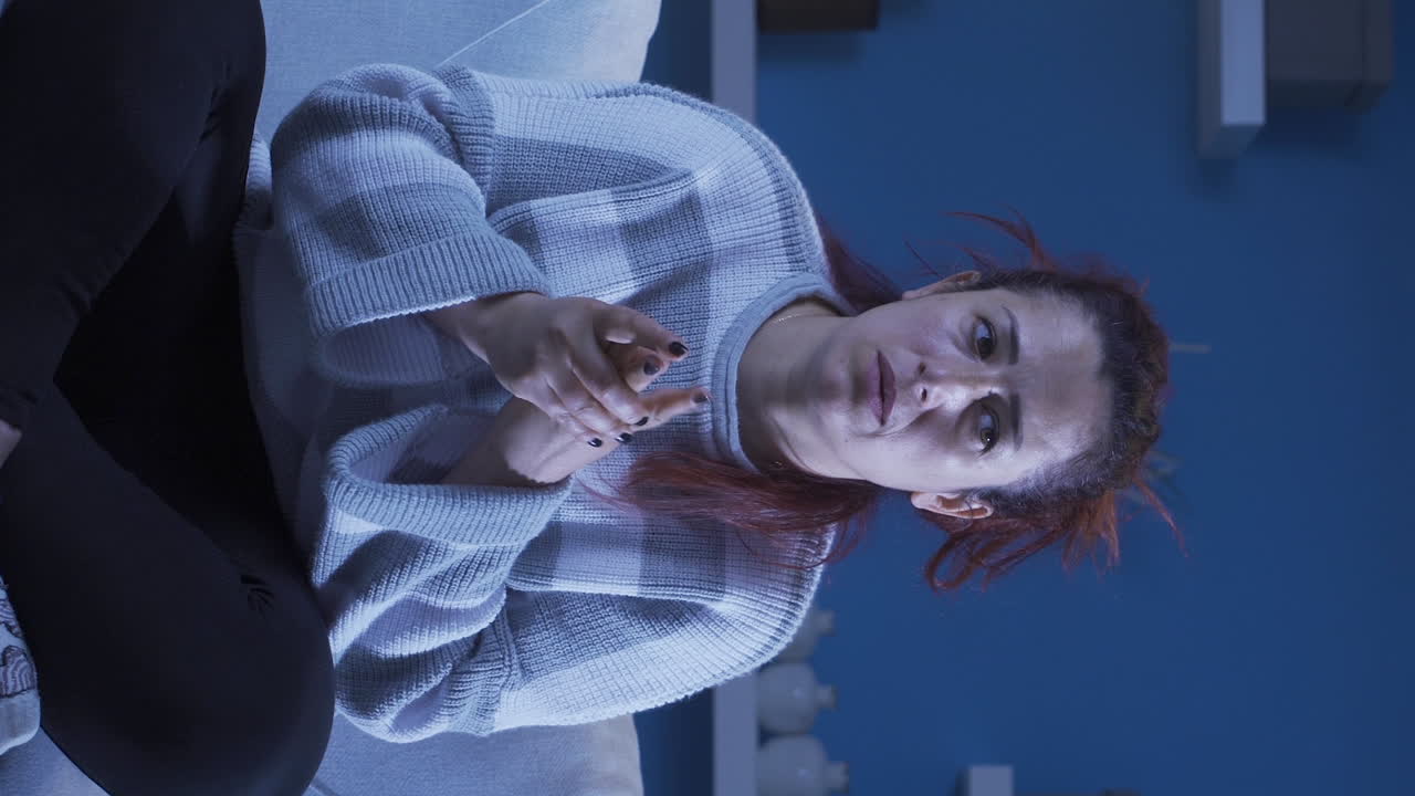 vídeo vertical de la mujer balanceándose nerviosamente en su asiento.