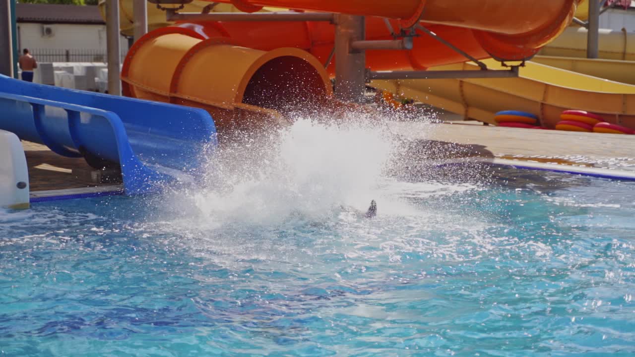 Slider in swimming pool. Children on waterslide in aqua park