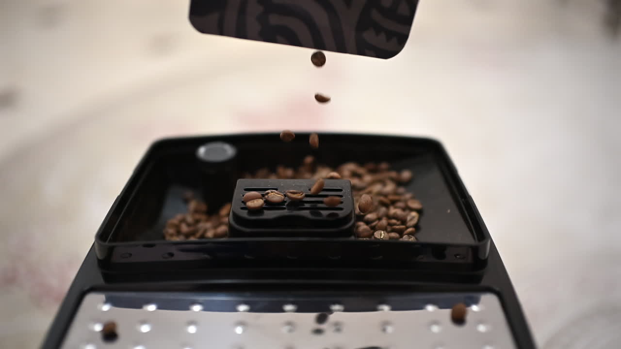 Primo piano di chicchi di caffè tostati versati in un macinacaffè