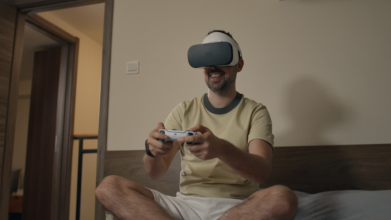 Man plays intense virtual reality game with controller while sitting on bed indoors