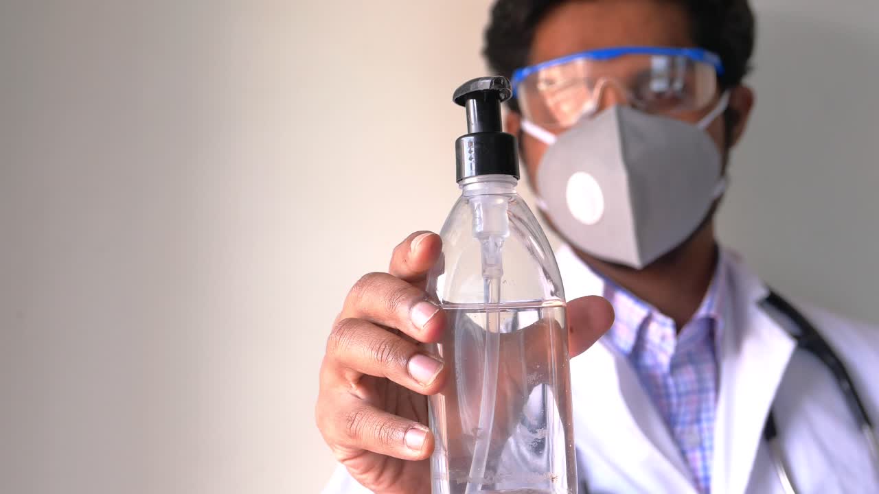 médico con desinfectante para las manos
