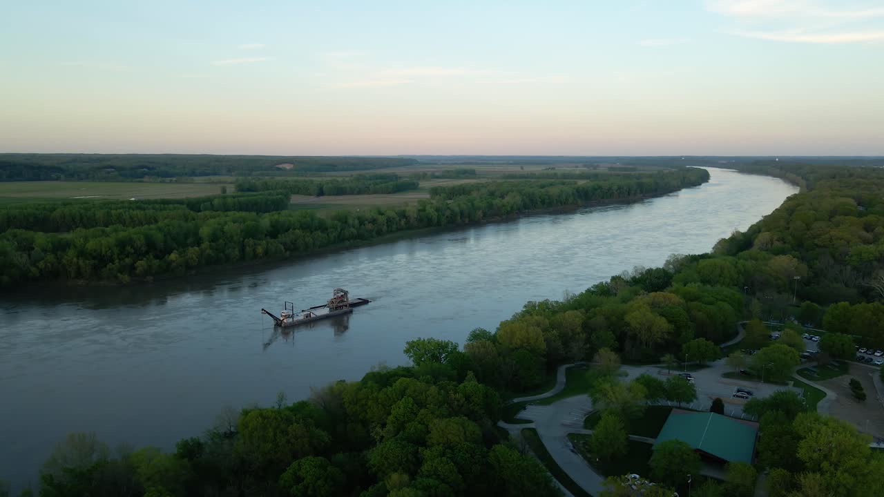 vista aérea alrededor de una máquina de dragado en el río missouri, atardecer en estados unidos - dando vueltas, disparo de drones