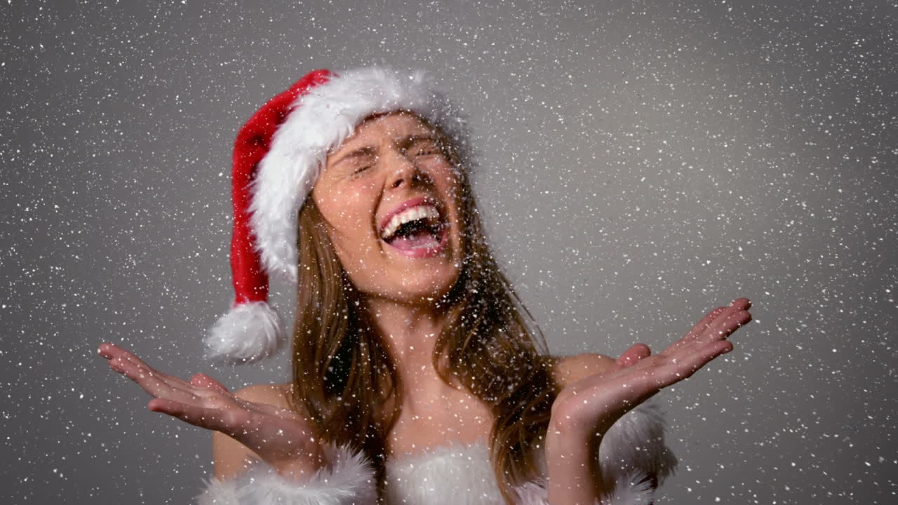 Composição de vídeo com neve caindo sobre menina feliz em traje de Papai Noel