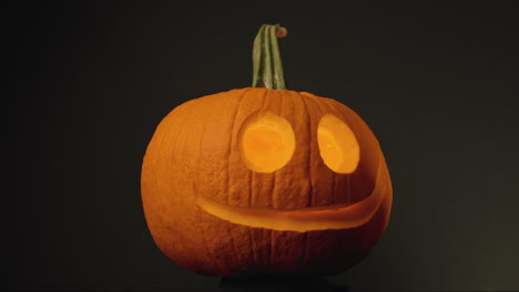 pumpkin head - pumpkin with carved round eyes and mouth in black background