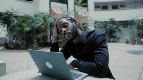 stressed businessman working on laptop outdoors