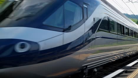 silver train speeding along the railway, reflecting vibrant green landscapes and a bright blue sky, providing comfortable and scenic transportation for travelers on an exciting journey