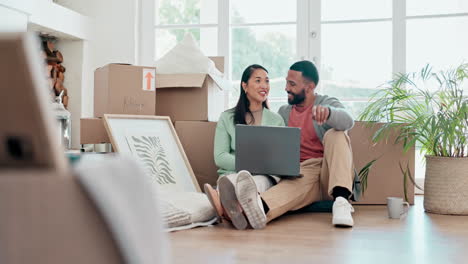 pareja feliz, cajas y computadora portátil en el nuevo hogar