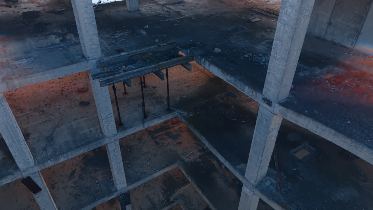 Empty floors of the abandoned construction site. Sunlight goes through the opened spaces of the building