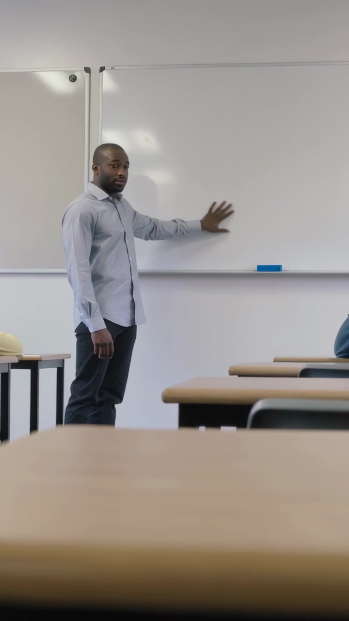 Vertical video: Reaching hand, teacher in shirt placing hand on board in class, drawing attention