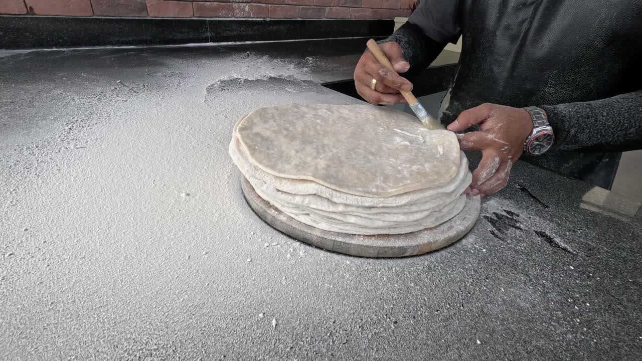 Sequence of an artisan hand-making flatbreads.