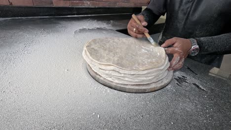 secuencia de un artesano haciendo panes planos a mano.
