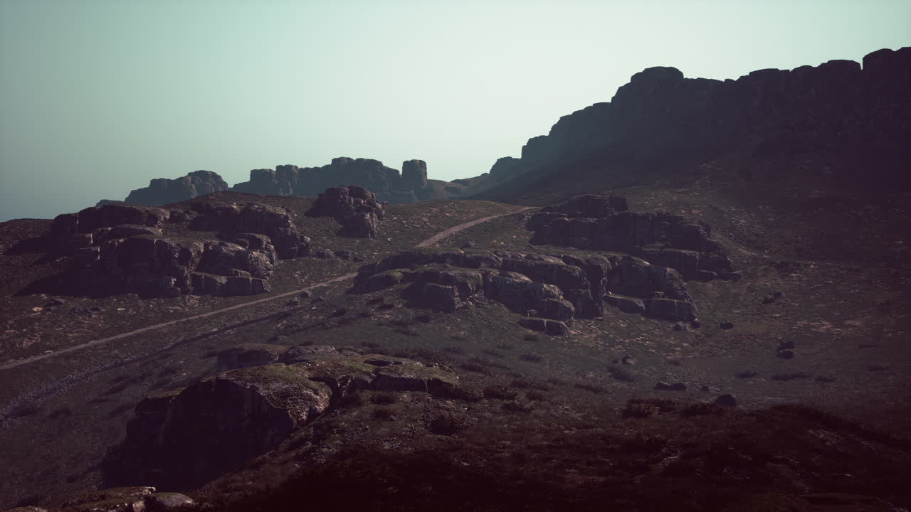 una montaña rocosa con un camino de tierra que lo atraviesa camino de montaña