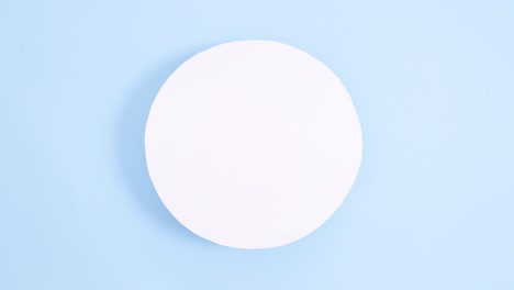 creative easter eggs and carrots appear under paper card note on bright blue background. stop motion minimal flat lay