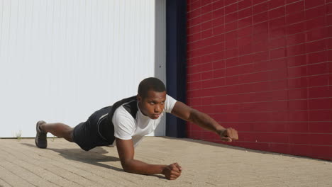 young black man stretching before running outdoors