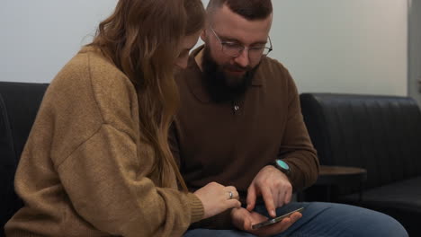 happy couple with device indoors