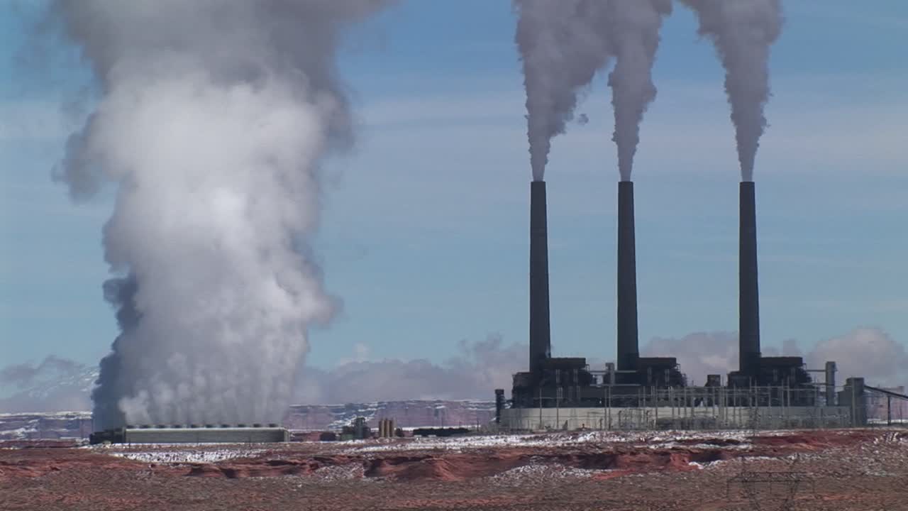 ripresa media di una fabbrica che rilascia inquinamento nel deserto dell'arizona