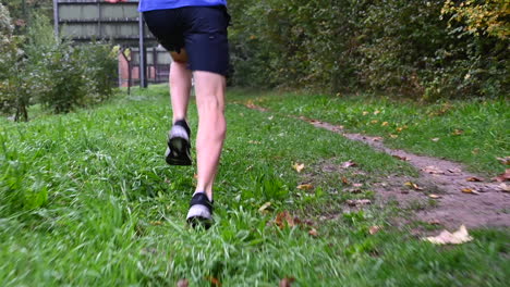 slow motion: a runner is on the grass and shows the underside of the sole with his long stride