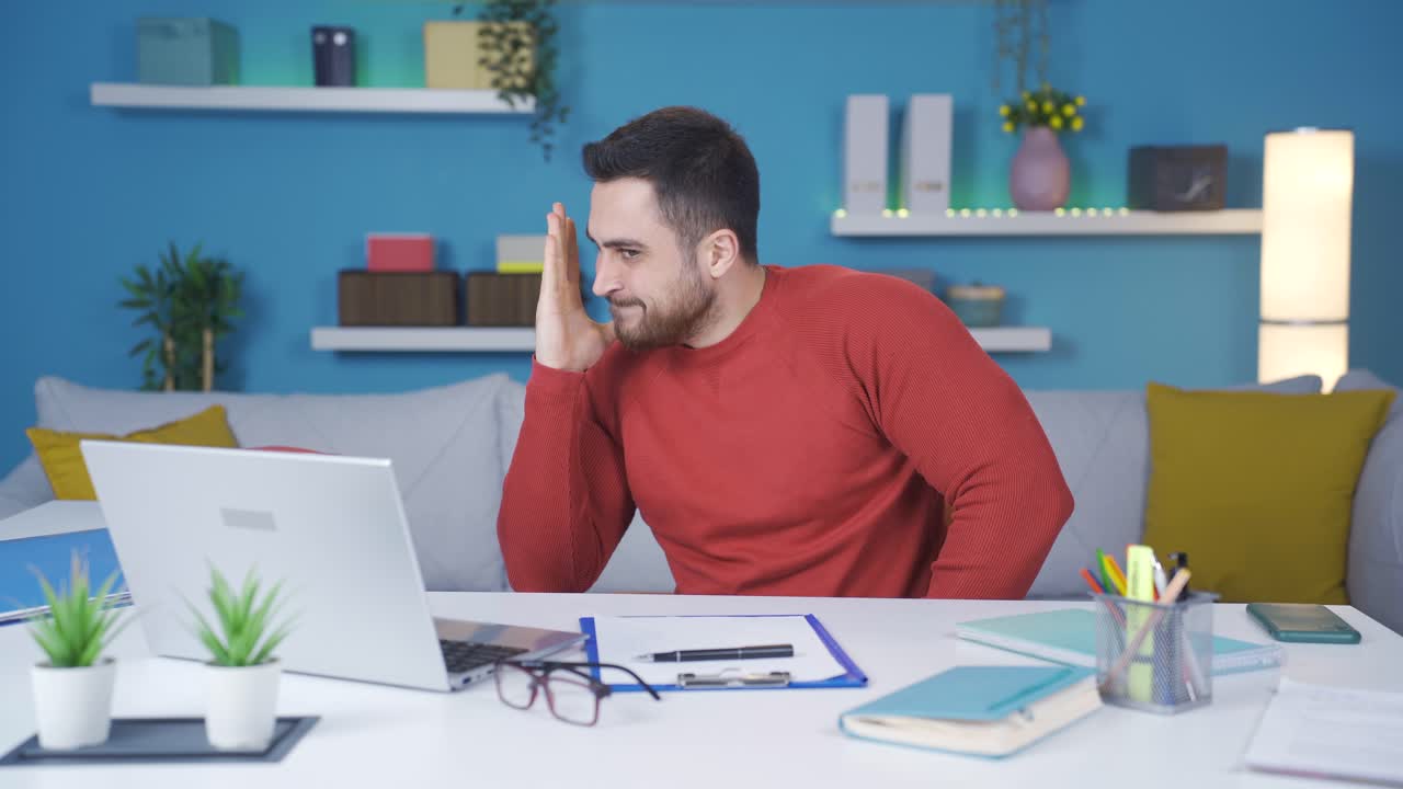 Der Mann im Homeoffice wird gestresst und frustriert von dem, was er auf dem Laptop sieht.
