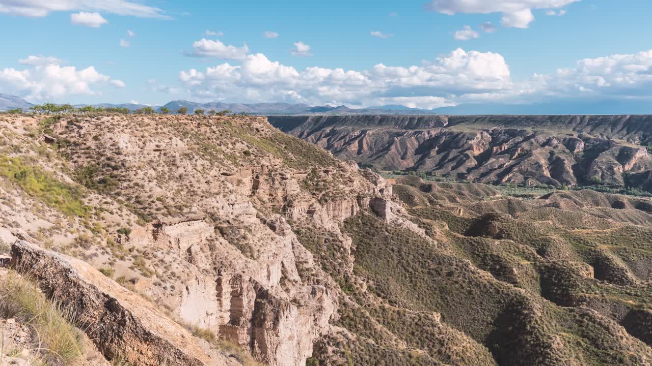 Moving clouds over rocky cliffs in Gorafe canyon landscape
