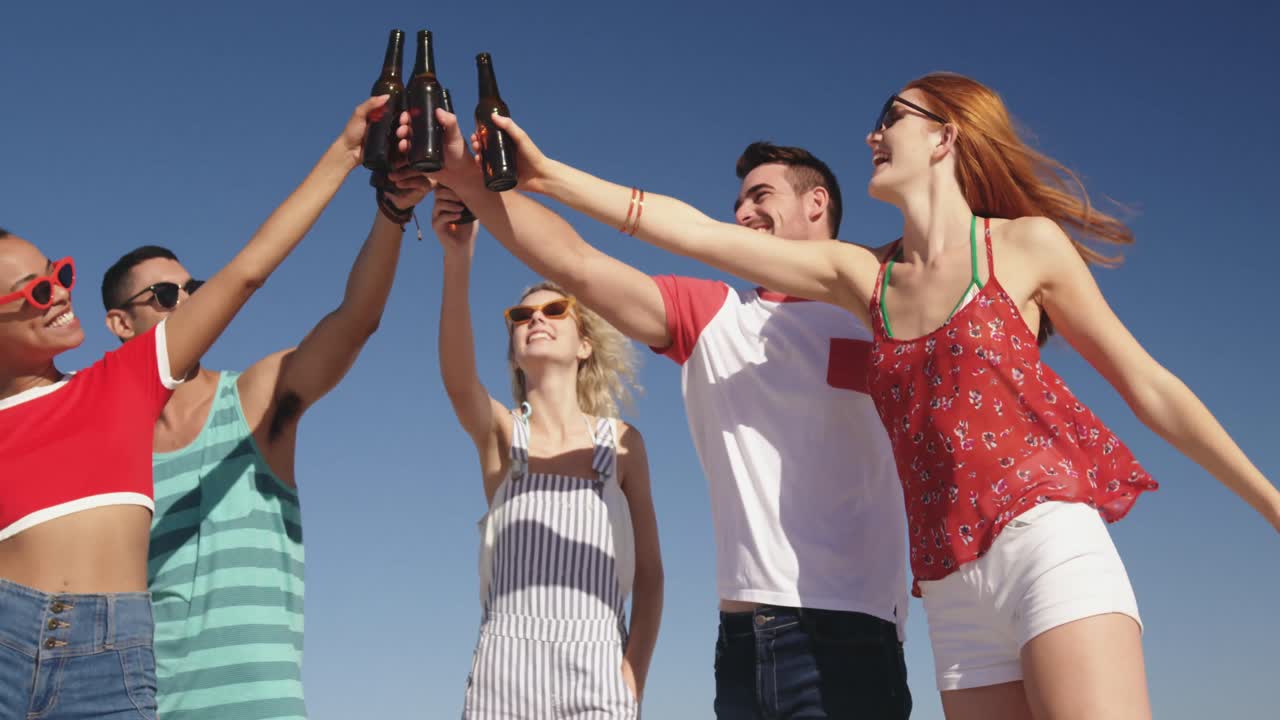 Giovani amici adulti che fanno un barbecue in spiaggia 4k