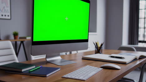 modern office workspace with green screen monitor