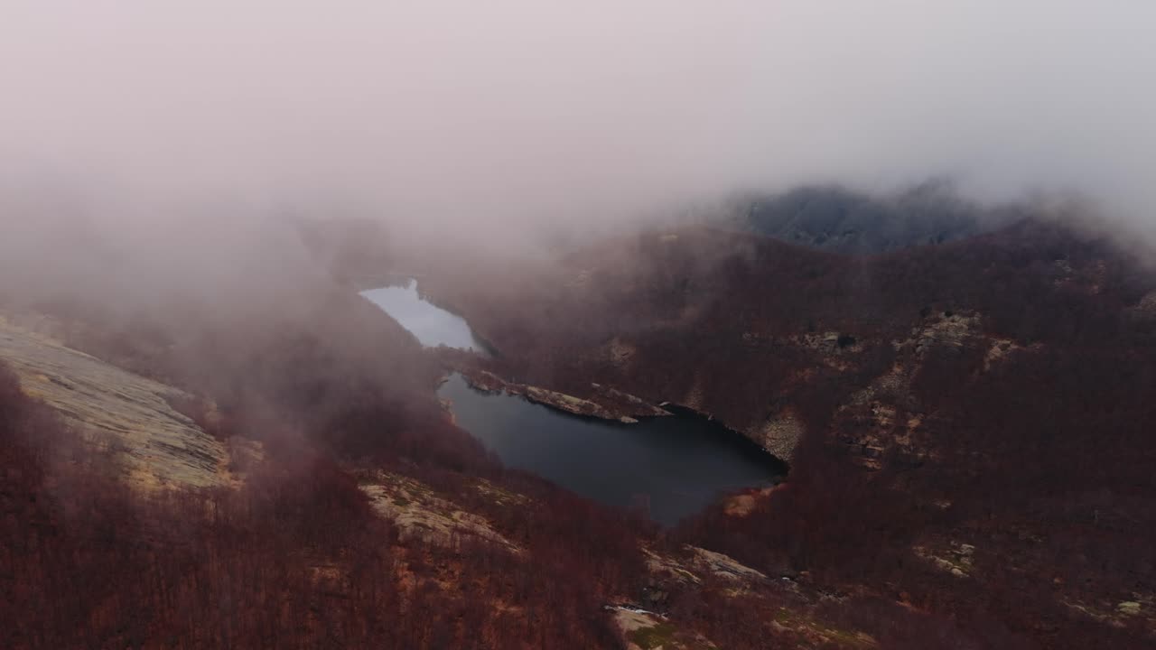 Misty aerial view of a serene mountain lake in the Dolomites Mountains region