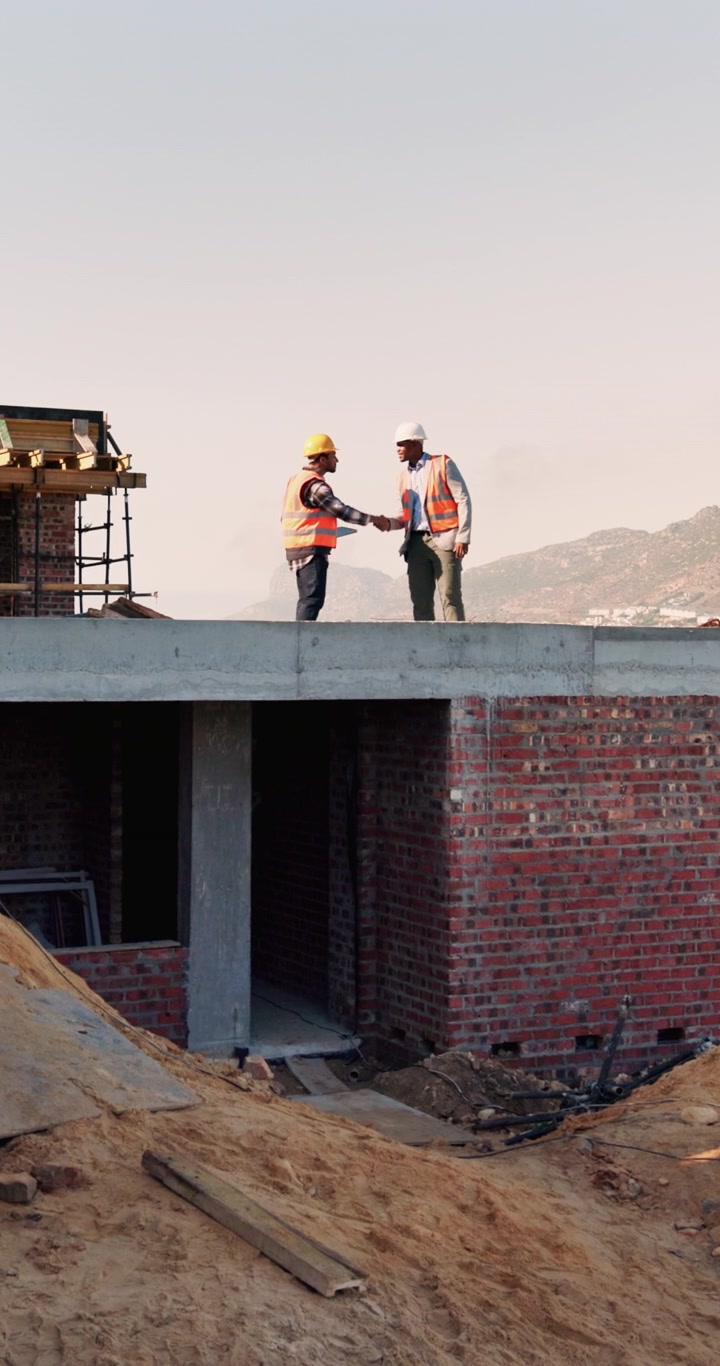 Construction Workers Shaking Hands on Building Site