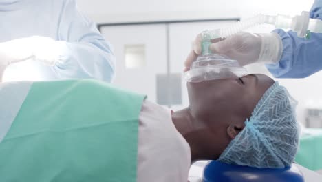 Sleeping-african-american-female-patient-with-oxygen-mask-during-surgery-in-slow-motion,-unaltered