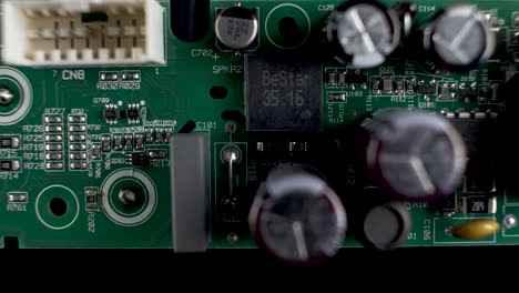 close up view of green pcb with transistors and chips