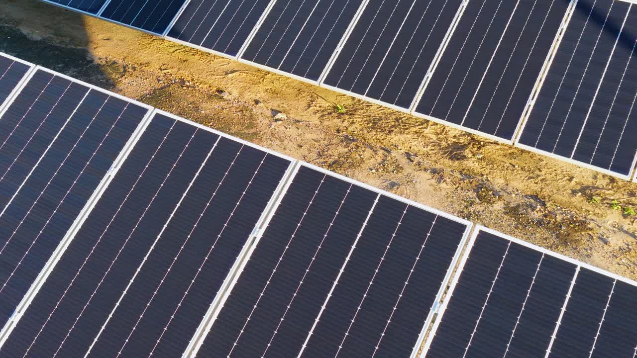 Drone footage captures solar panels in a sunlit farm, highlighting renewable energy and sustainability with clear skies and vibrant lighting