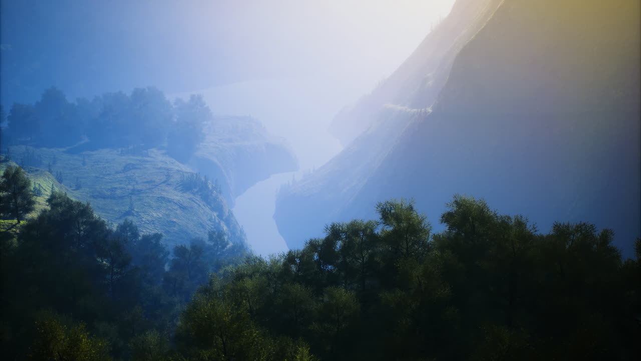 Misty river flowing through a serene valley at dawn in a mountainous region