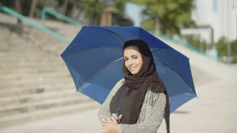 Junge-Muslimische-Frau-Im-Hijab-Versteckt-Sich-An-Sonnigen-Tagen-Unter-Einem-Regenschirm.