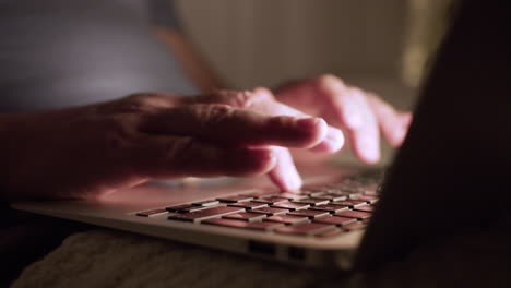 closeup of old man typing on bed