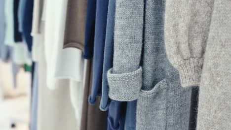 close-up of several new winter garments hanging on a coat rack