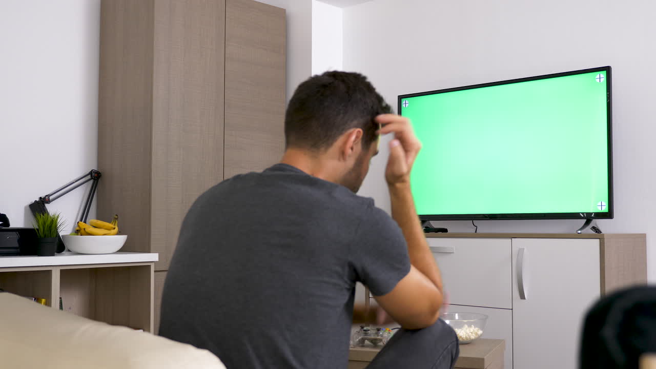 Man Watching Green Screen Television at Home