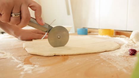 closeup 4k footage of young woman cutting dough for pie with special round cutter knife