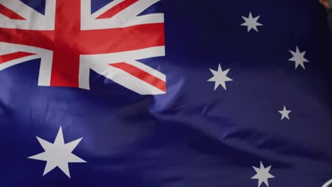 Animation-of-football-over-flag-of-australia-with-copy-space