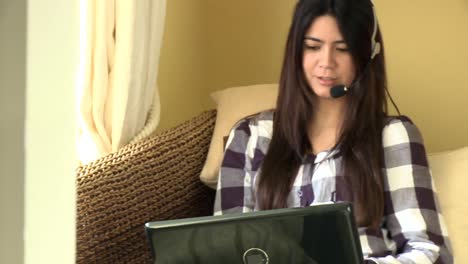 mujer feliz trabajando en un portátil con auriculares