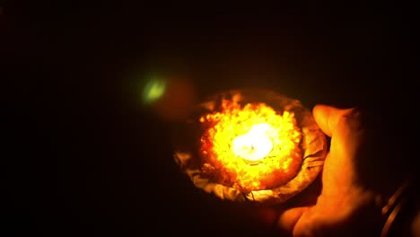 man places a ceremonial candle in the ganges