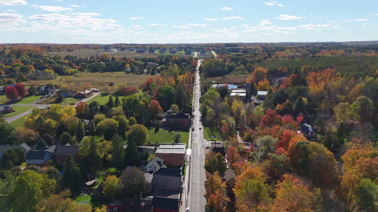 Cars Driving Through The Historic Village Of Alton In Caledon, Ontario During Fall. Aerial Flyover