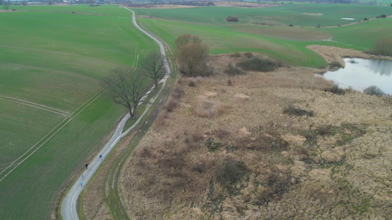 воздушный вид над сельской дорогой между сельскохозяйственными полями - снимок с беспилотника