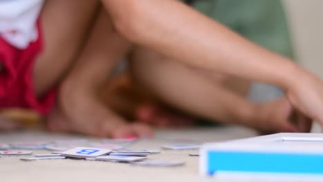 child playing with alphabet learning tiles on the floor