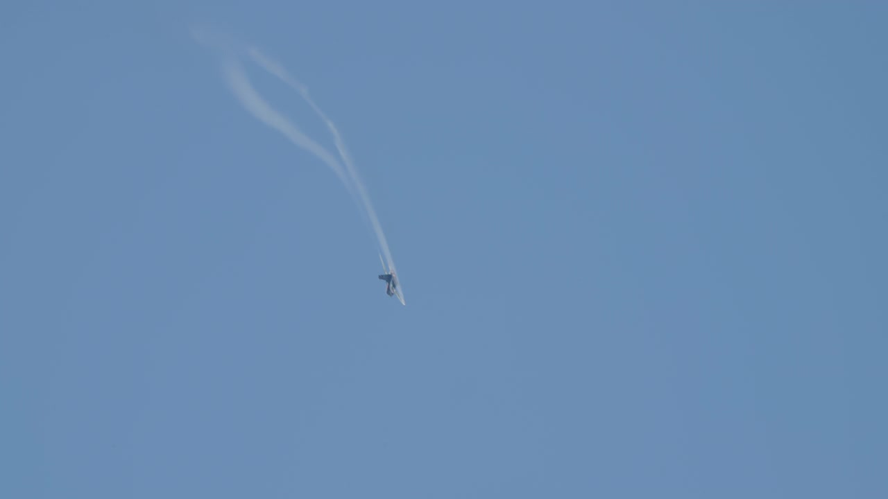 Caccia militare che esegue manovre acrobatiche nel cielo blu