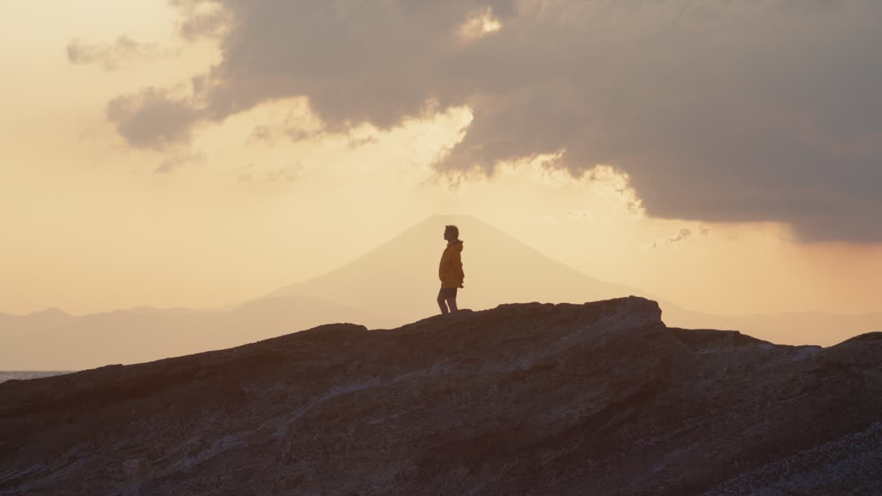 Woman at Edge of the World – Japanese Seascape
Framed by crashing waves and fading sun, a woman in yellow jacket stands quietly on coastal rock, wind brushing past.