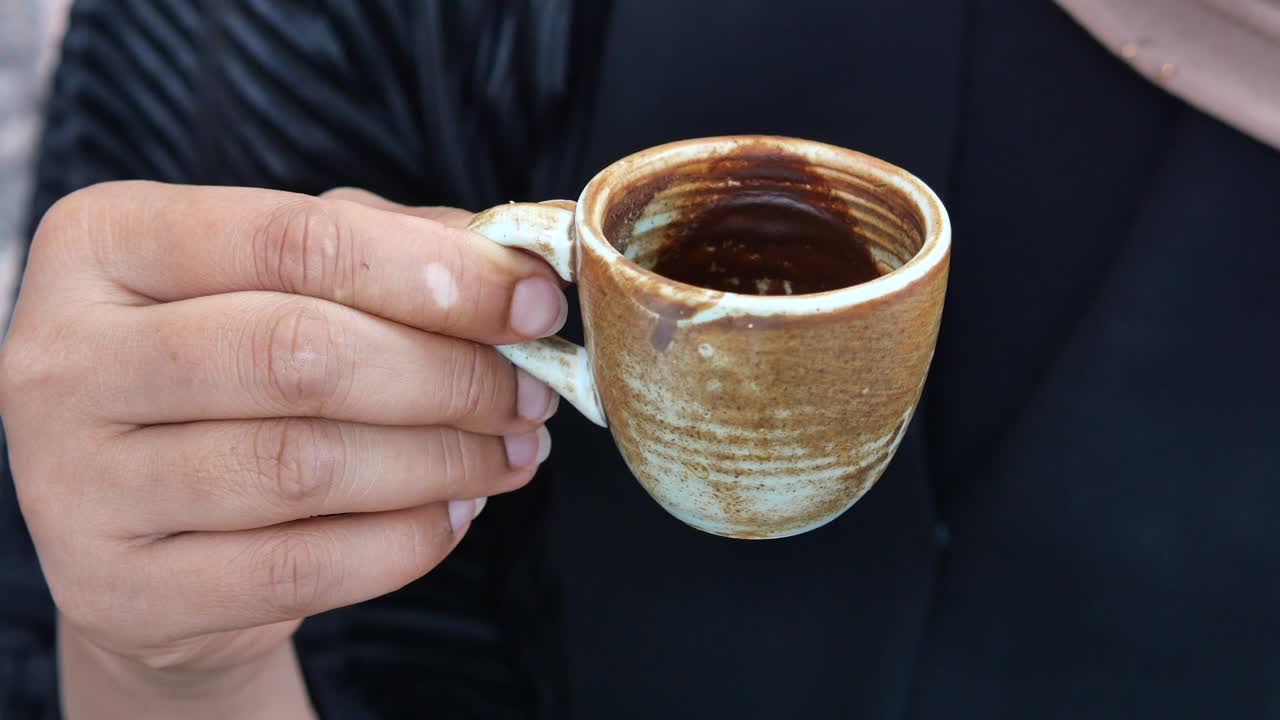 커피 한 잔 을 들고 있는 손