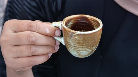 a hand holding a cup of coffee