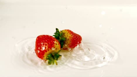 Two-strawberries-falling-into-water-