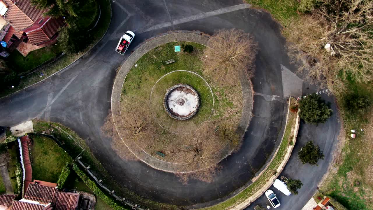 кинематографический воздушный кадр круговорота с машиной, проезжающей через него